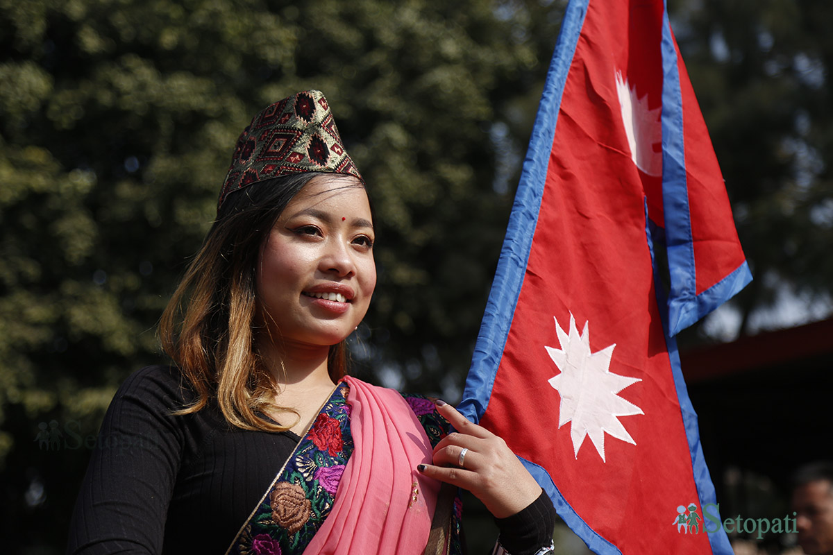 टोपी दिवसको अवसरमा काठमाडौंमा आयोजित कार्यक्रममा नेपाली टोपी र झण्डा बोकेकी एक युवती। तस्बिर : नवीनबाबु गुरुङ/सेतोपाटी